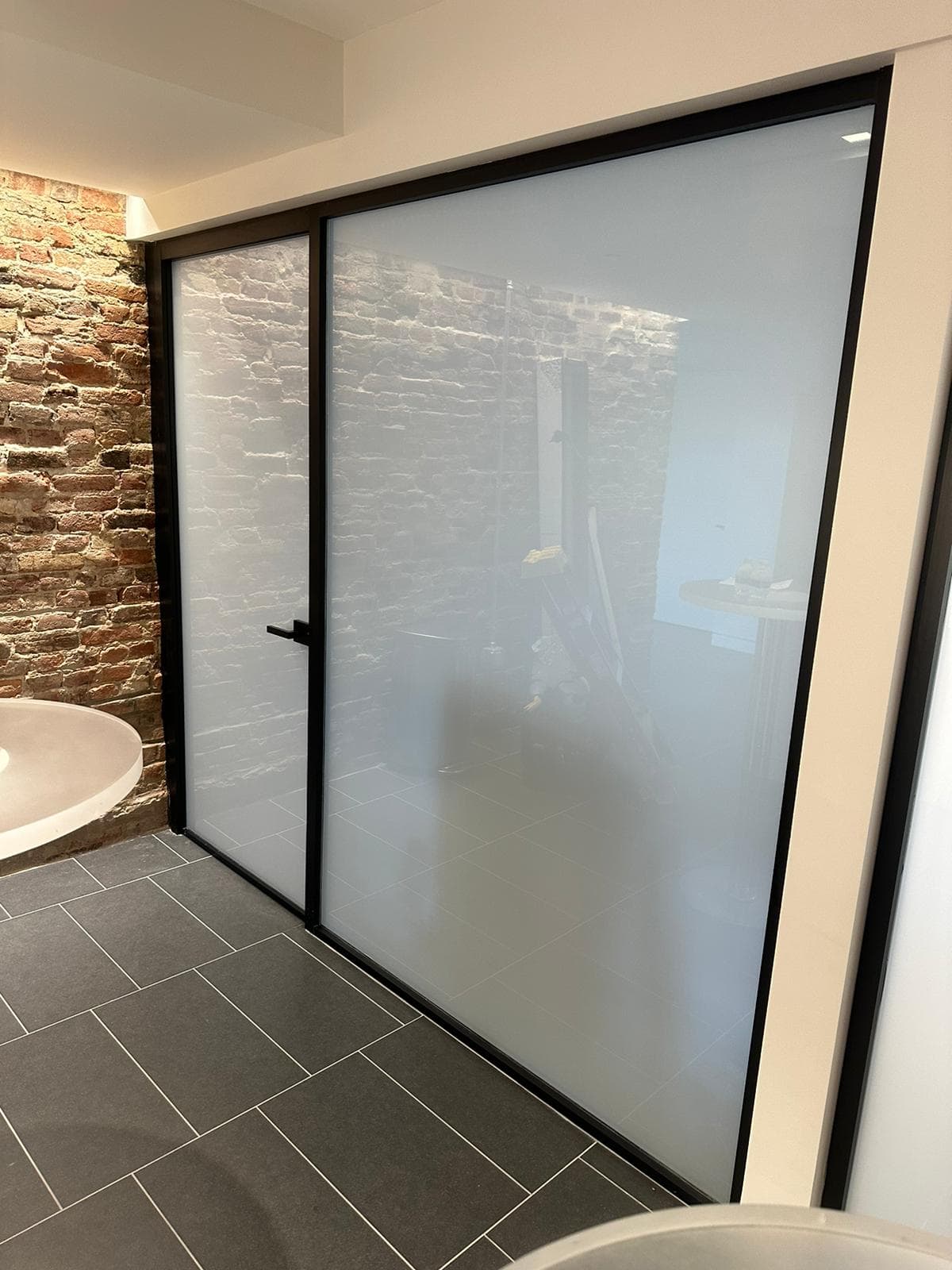 Full-height frosted door softly concealing the space beyond