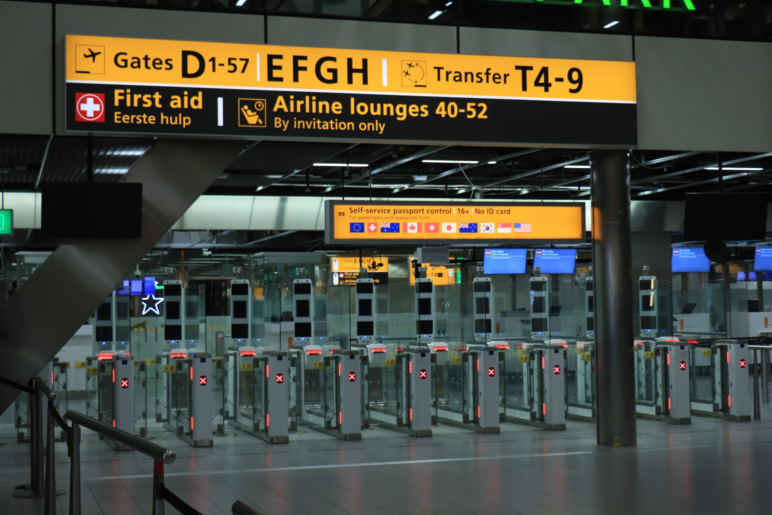 Yellow terminal directory signage with gate directions and first aid