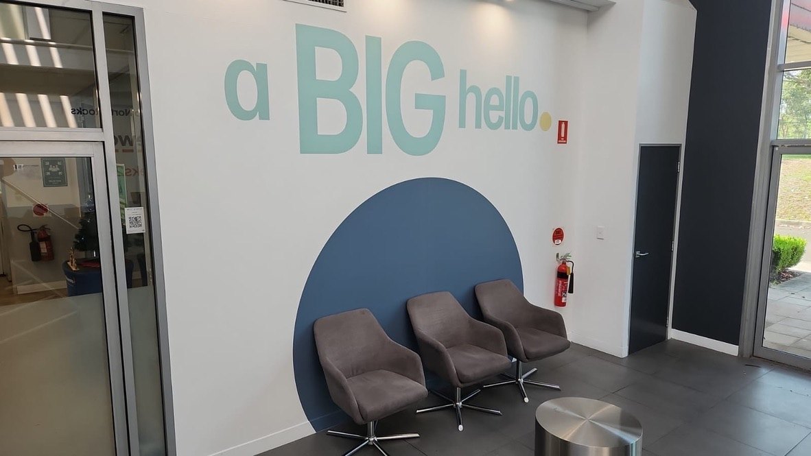 'a BIG hello' painted brand mural in a corporate lobby waiting area