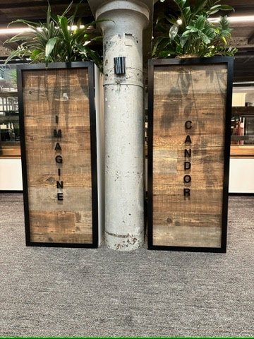 Timber panel feature with 'Imagine' and 'Candor' cut-vinyl wayfinding