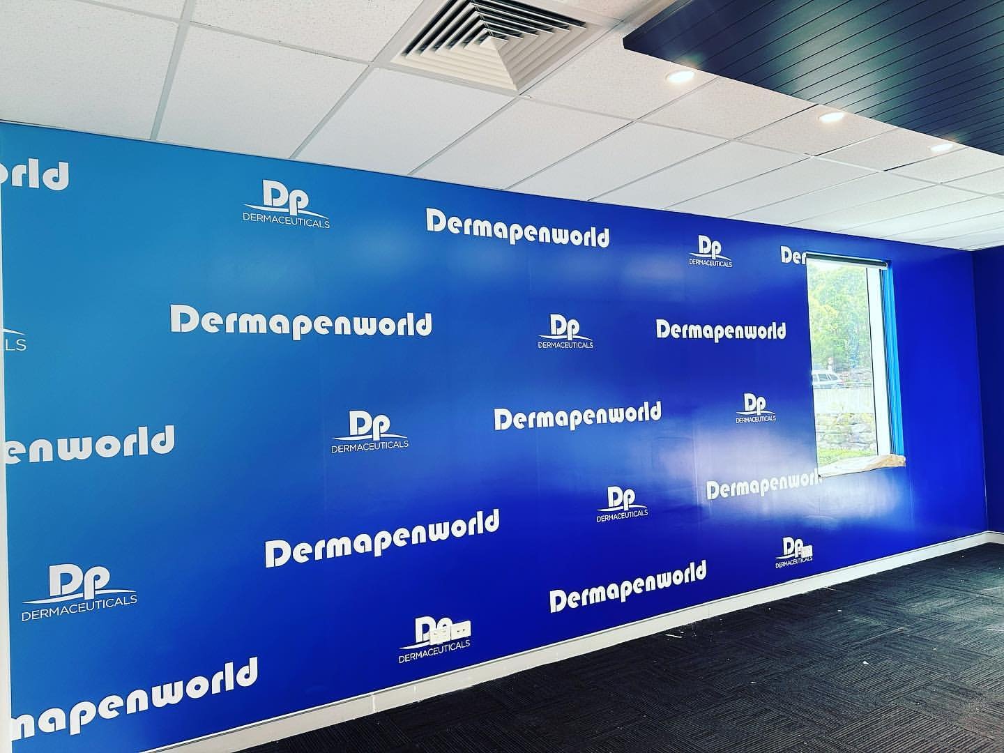 Dermapenworld blue step-and-repeat media wall